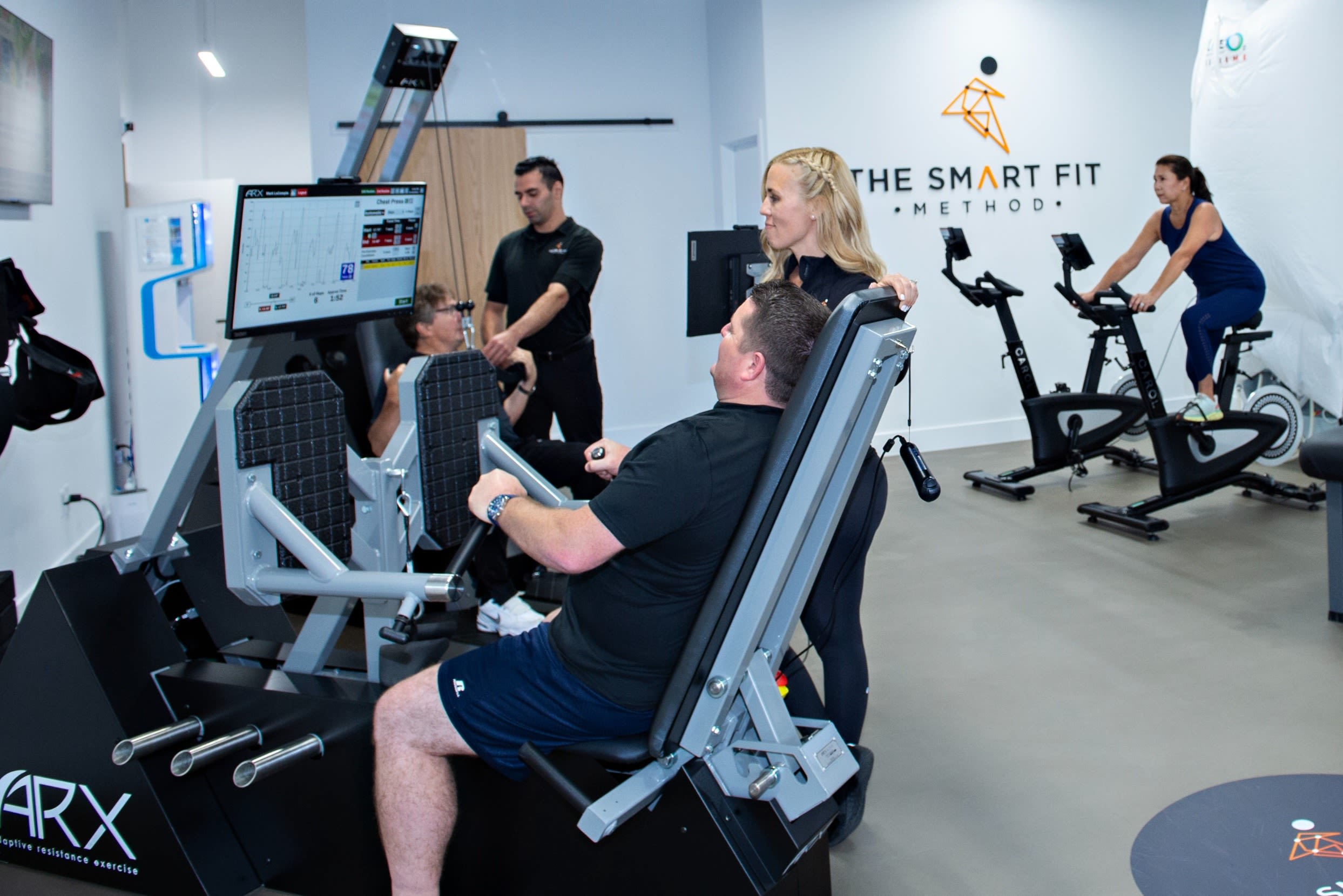 A member using an ARX resistance machine with a trainer